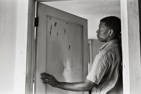 Jerome Smith Inspects Bullet Holes in Door, 1963, 16 x 20&nbsp;Inches, Silver Gelatin Photograph, Edition of 25
