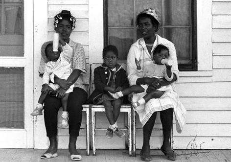 Two mothers with children watching marchers on porch, Selma to Montgomery, Alabama Civil Rights March, March 23-25, 1965